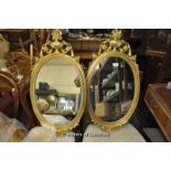 A pair of modern Georgian design oval wall mirrors with urn surmounts, 78cm overall.