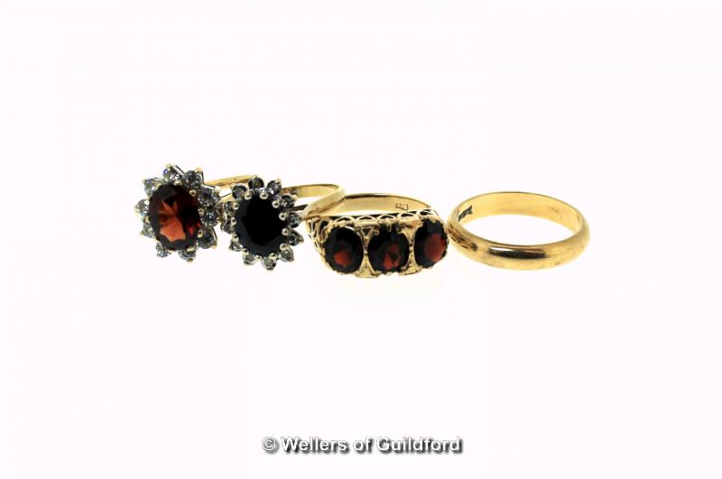 Three 9ct yellow gold stone set rings, including a three stone garnet ring, together with a 9ct