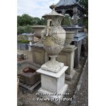 *RECONSTITUTED STONE TWIN HANDLED URN ON PLINTH WITH GRAPE AND VINE DETAIL AND ACORN TOPPED LID. URN