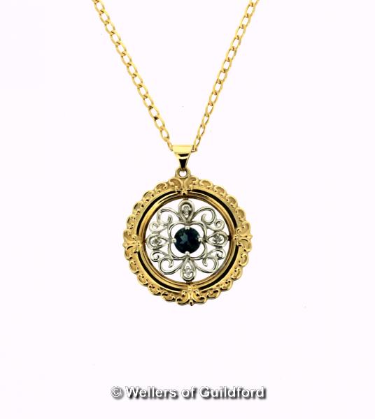 Circular openwork pendant set with diamonds and a central blue stone, mounted in yellow and white