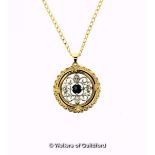 Circular openwork pendant set with diamonds and a central blue stone, mounted in yellow and white