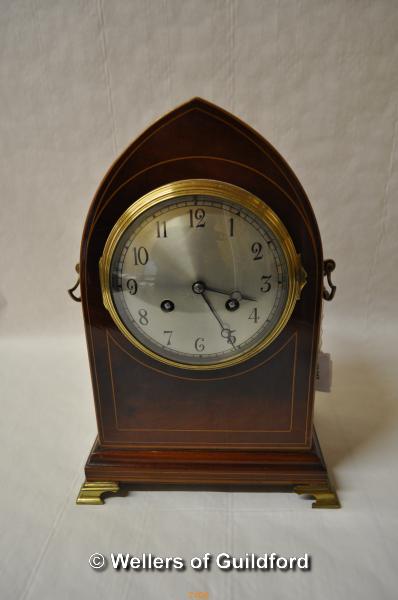 A late 19th Century mahogany mantel clock with arched top, boxwood stringing, the silvered dial with