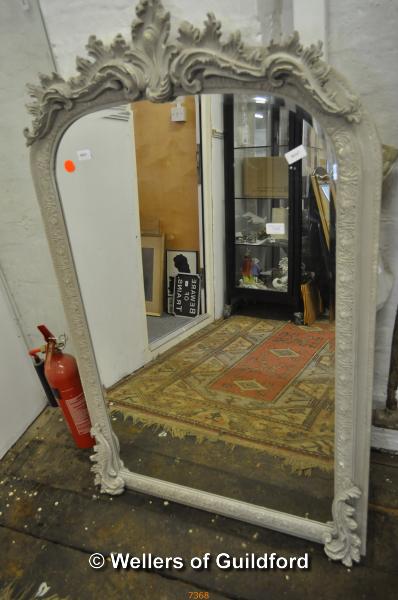 A grey painted wall mirror, the arched top moulded with flowers, Nordic Style London label, 138 x