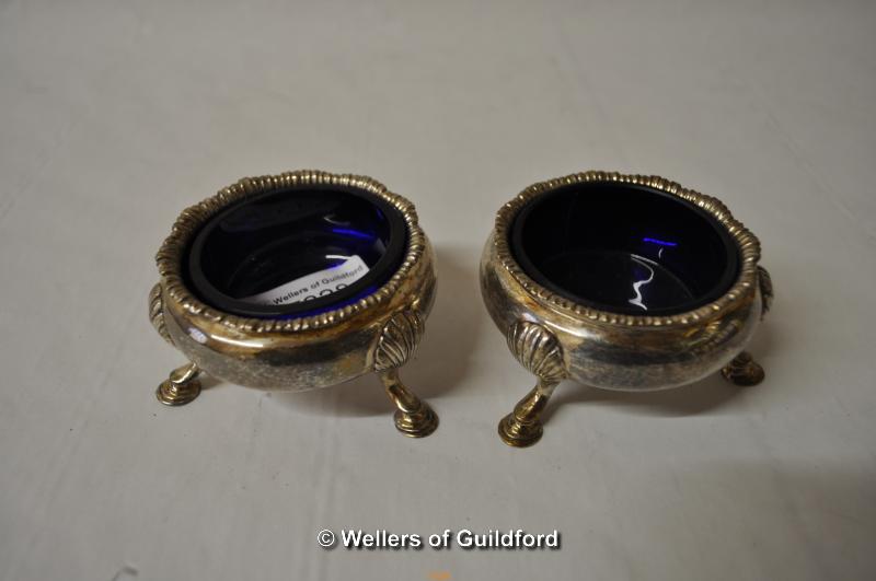 A pair of silver salts raised on scroll legs with shell knee, marks rubbed, 144g.