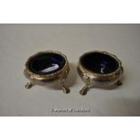 A pair of silver salts raised on scroll legs with shell knee, marks rubbed, 144g.