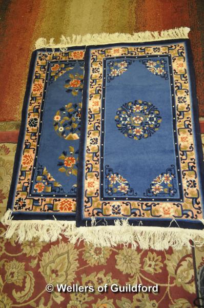 A pair of Chinese blue and pink rugs, 108 x 62cm.