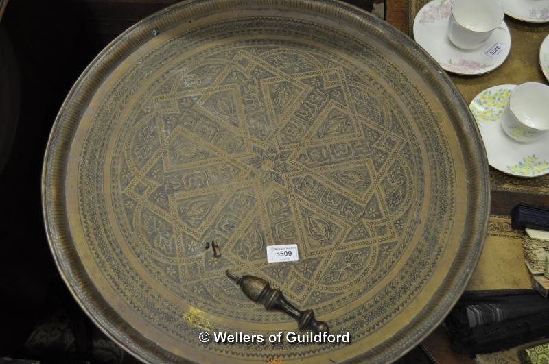 A circular Indian brass tray and an oak framed mirror.