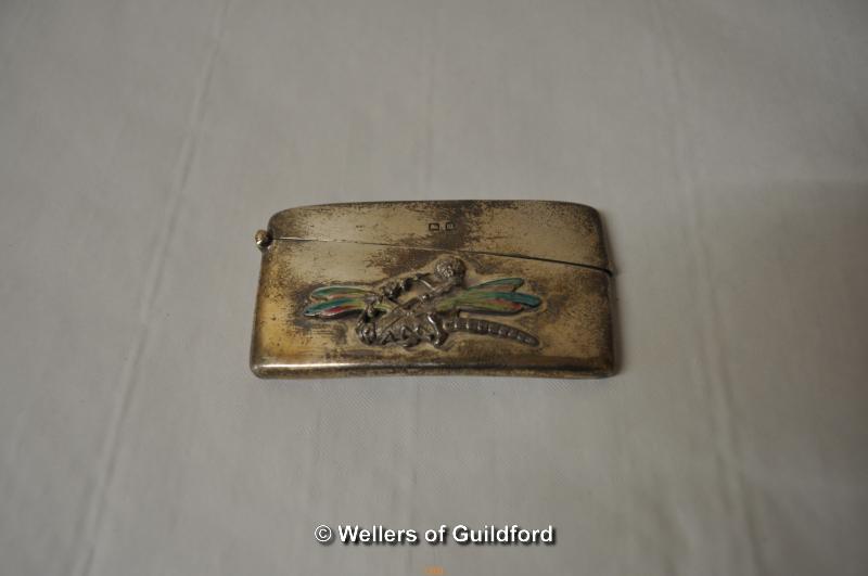 A curved silver card case with applied motif of cherub riding a dragonfly with enamelled wings,