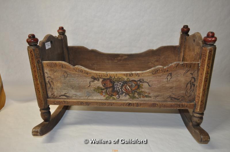 A small Continental cradle with painted decoration dated 1872, 54cm long.