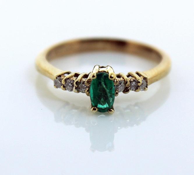 Emerald and diamond ring, oval cut emerald with three round brilliant cut diamonds set to either