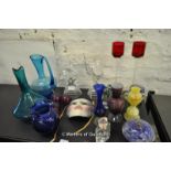 Decorative glassware including two dancer figurines, pair of tall red glass candle holders, blue