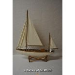 A 20th Century wooden pond yacht on separate stand, 58cm.