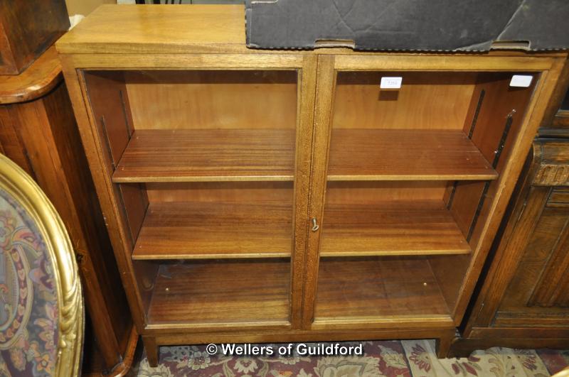 A mid 20th Century glazed display cabinet with two door, 91cm wide.