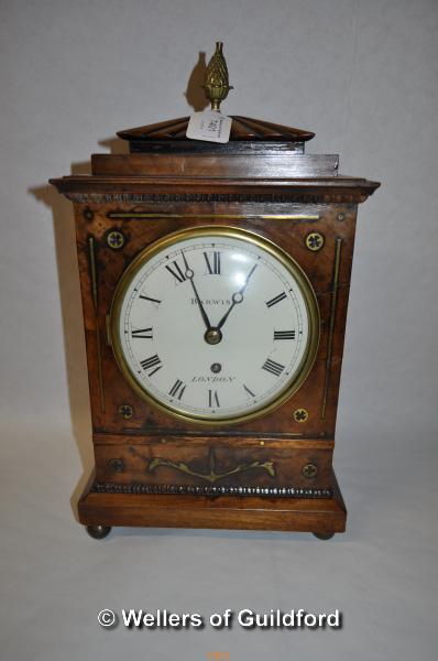 An early 19th Century mahogany cased mantel clock with pineapple finial and brass inlay, the white