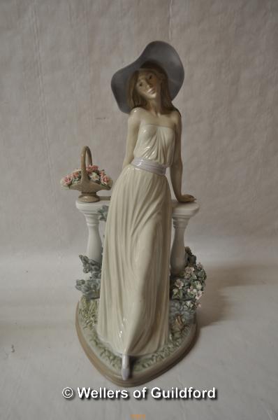 Lladro figure of a lady wearing a large hat leaning on a balustrade, 35cm.