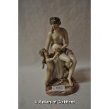 A 19th Century porcelain figure of a nude seated on a rock, a young cherub beside her, 21cm.