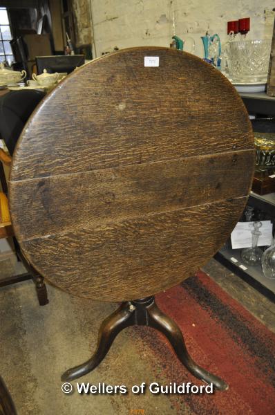 An oak circular tilt top tripod table, 74cm diameter.