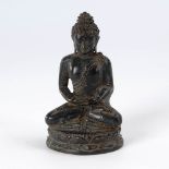 Kleiner Buddha mit dunkler Patina. Auf schmalem, doppeltem Lotosthron sitzende Figur im