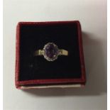 An amethyst and diamond oval cluster ring in gold