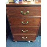 A tall narrow chest of four drawers.