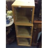 A set of three oak and glass mounted cabinets.