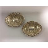 A heavy pair of embossed bonbon dishes with scroll