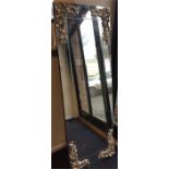 A large tall dressing mirror with scroll decoratio