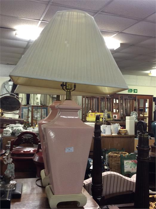 A pair of large pink lamps and shades.