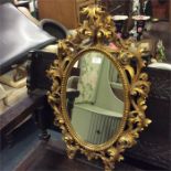 An attractive gilt mirror decorated with scrolls.