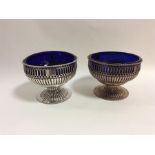 A pair of Georgian silver bowls with crested sides