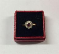 A ruby and diamond circular cluster ring in 18 car