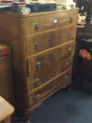 A walnut chest of five drawers.