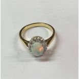 An attractive oval opal and diamond cluster ring i