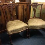 A pair of Edwardian armchairs.