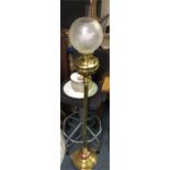 A brass oil lamp with glass shade.