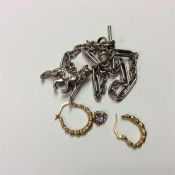 A pair of gold hoop earrings together with a silve