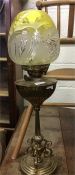 A brass mounted oil lamp with yellow glass shade.