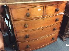 A small mahogany bow front chest of five drawers.