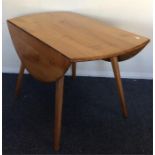 ERCOL: A kitchen drop leaf table on spreading supp