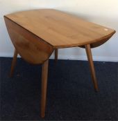 ERCOL: A kitchen drop leaf table on spreading supp