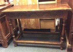 A small oak carved refectory table with stretcher