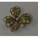 A demantoid garnet and pearl brooch in the form of