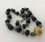 A heavy set of green and black beads with 22 carat