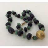 A heavy set of green and black beads with 22 carat