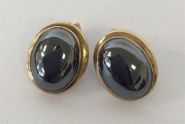 A pair of gold oval ear studs in plain mounts. App