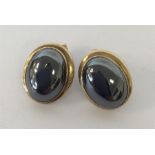 A pair of gold oval ear studs in plain mounts. App