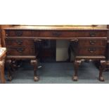 A mahogany twin pedestal seven drawer desk on ball