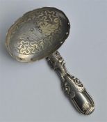 An Antique caddy spoon with embossed handle and en