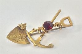 A gold brooch in the form of a shovel and pickax m
