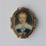 An oval miniature of a boy in gold frame with scro